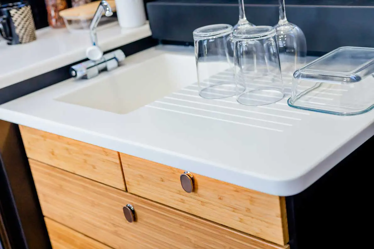 A sink with two drawers and a white counter top.