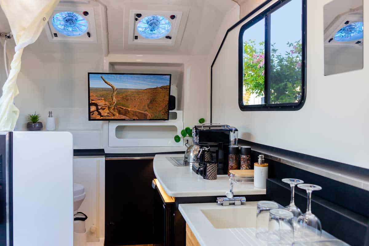 A kitchen with a sink and television in it