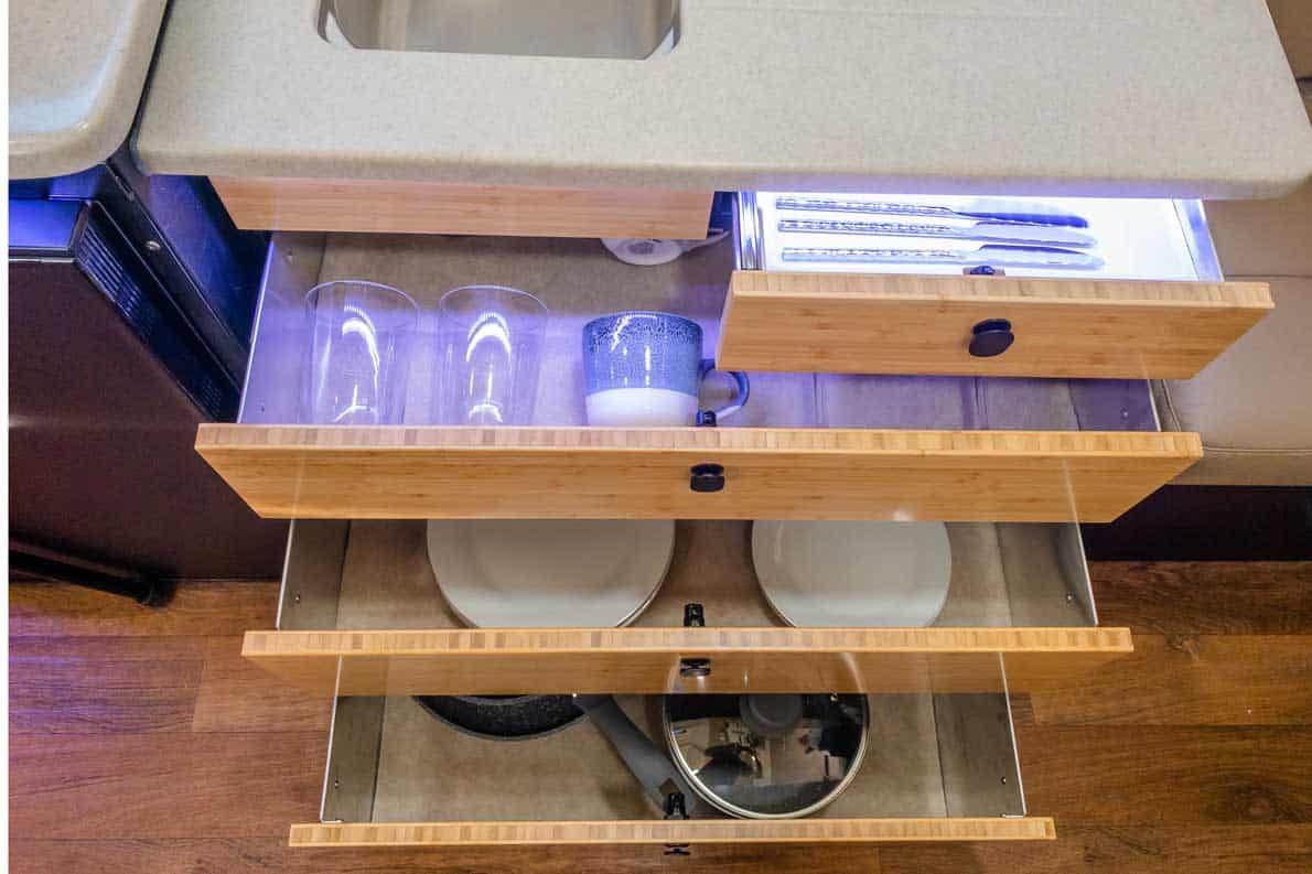 A drawer with many dishes and cups in it