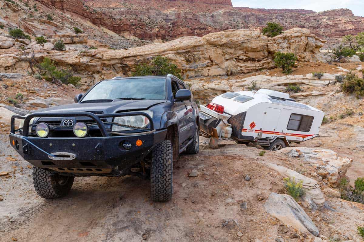 A truck and trailer are parked on the side of a mountain.