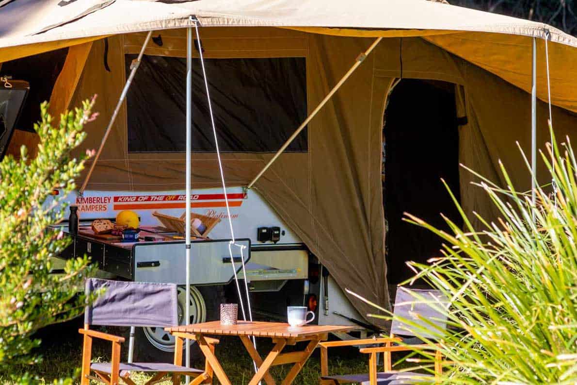 A tent with an awning and table in the middle of it