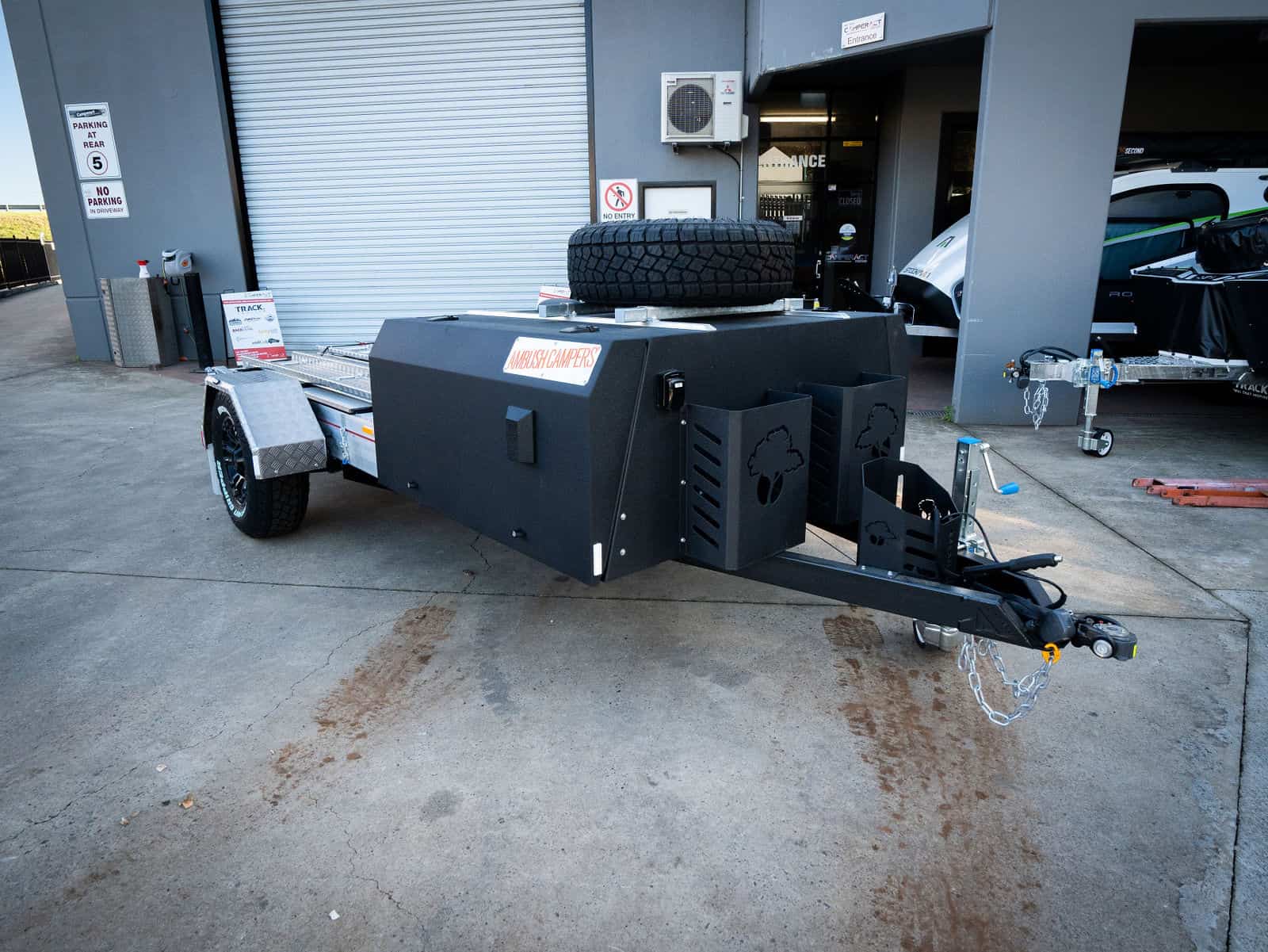 A black trailer with a large grill on it.