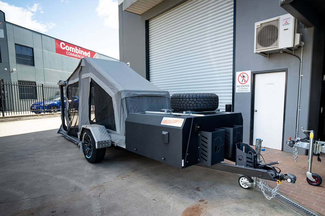 A trailer with an enclosed area and tire rack.