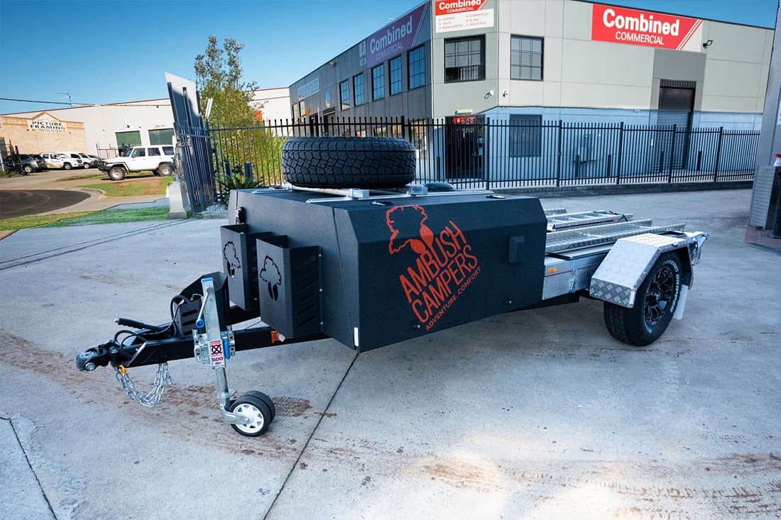 A black trailer with an orange and red logo on it.