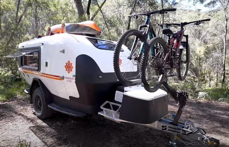 A bicycle rack attached to the back of an ambulance trailer.