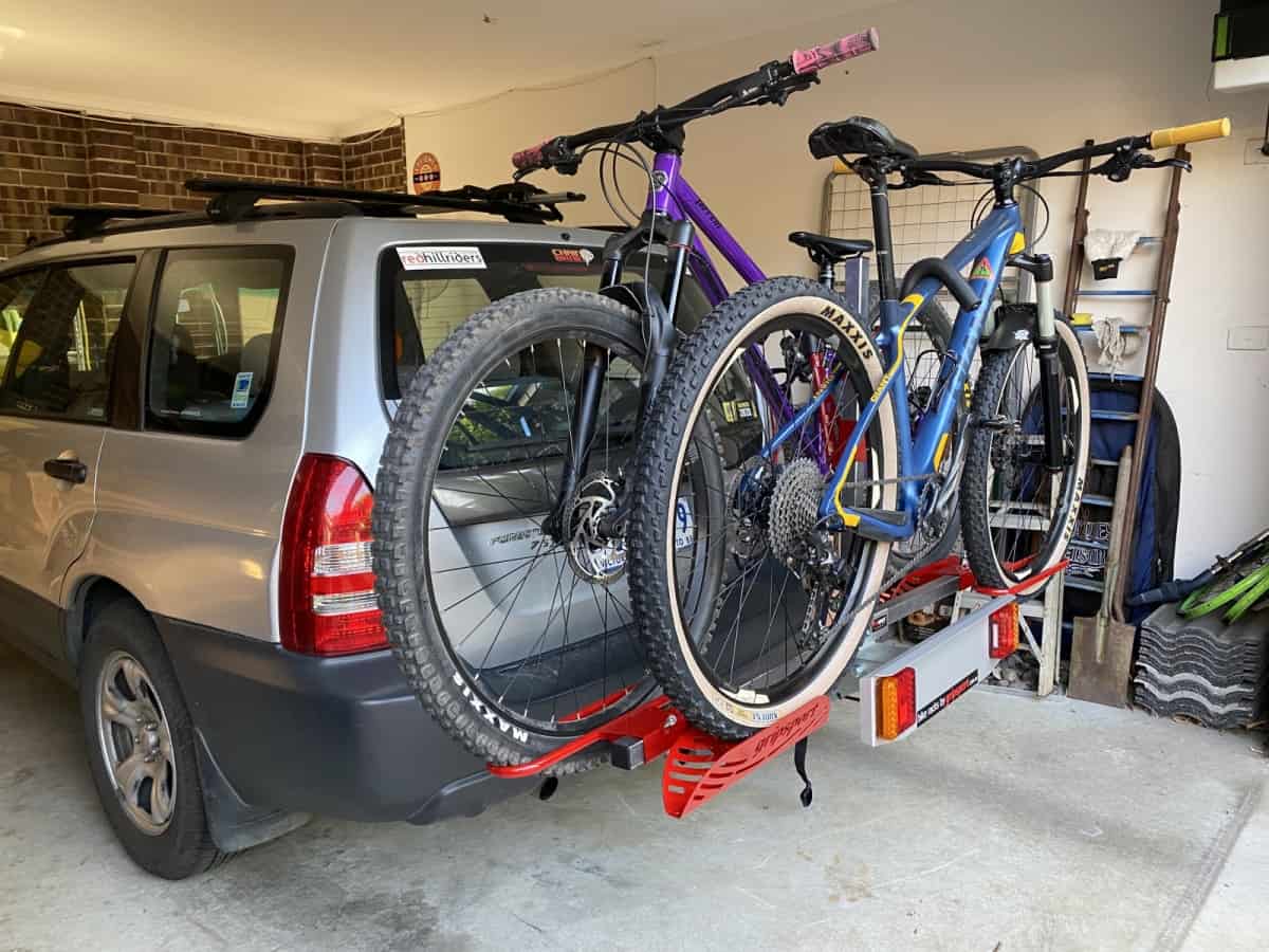 A car with two bikes on the back of it.