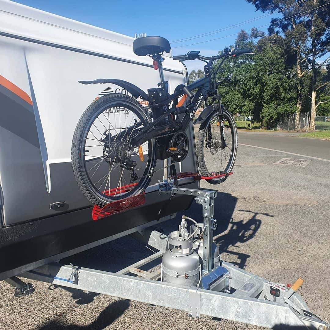 A bicycle is attached to the back of a trailer.