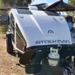 A white boat with a gas tank on top of it.