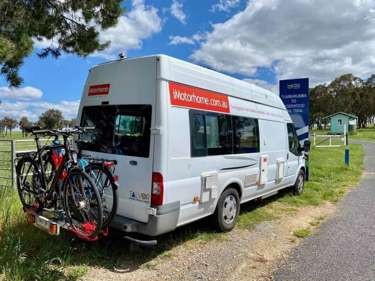 A white van with bicycles on the back of it.