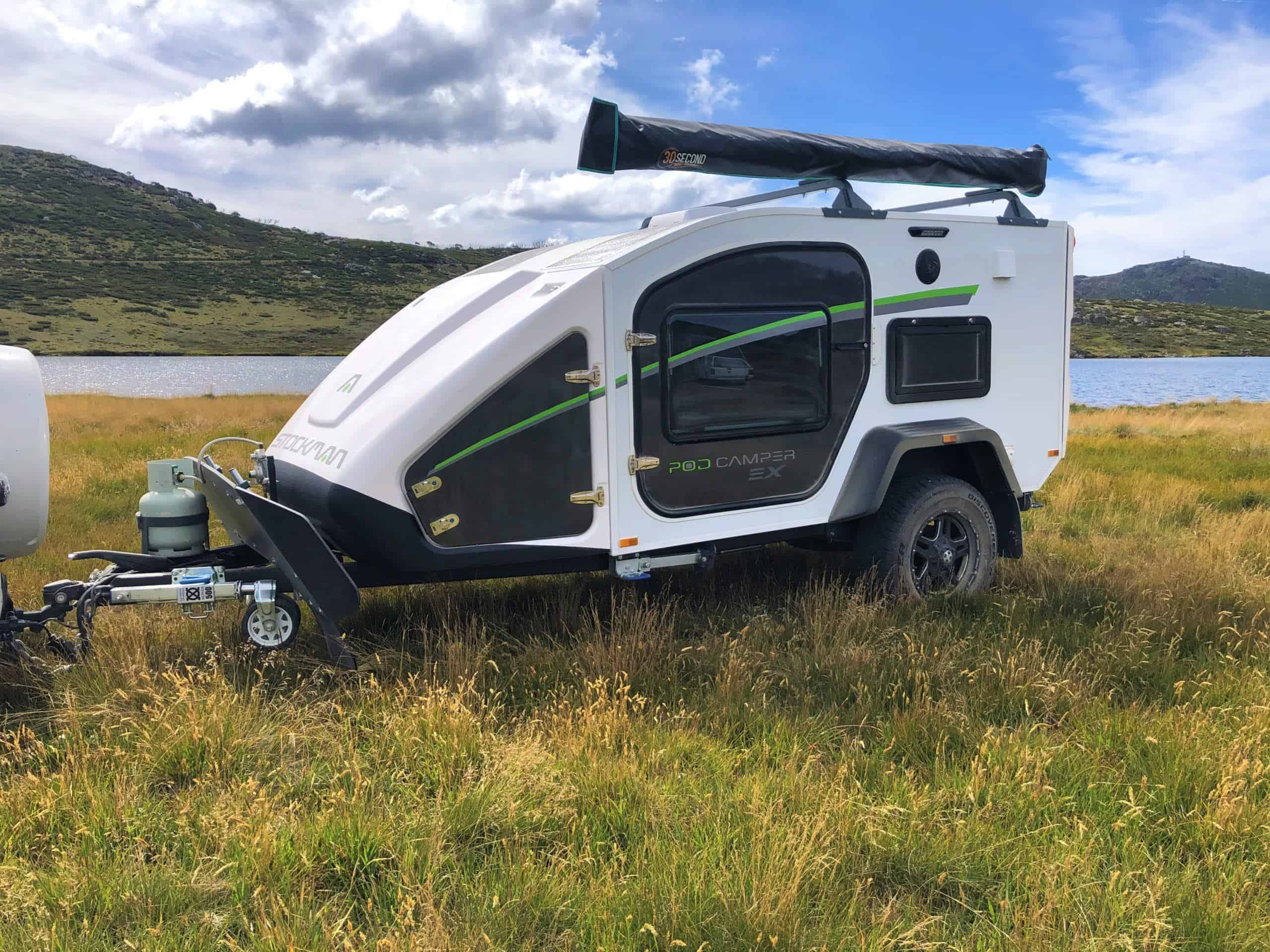 A small camper trailer in the middle of a field.