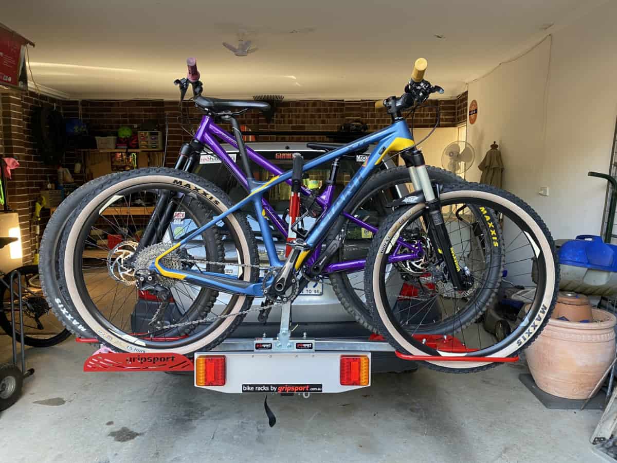 Two bikes are strapped to the back of a truck.