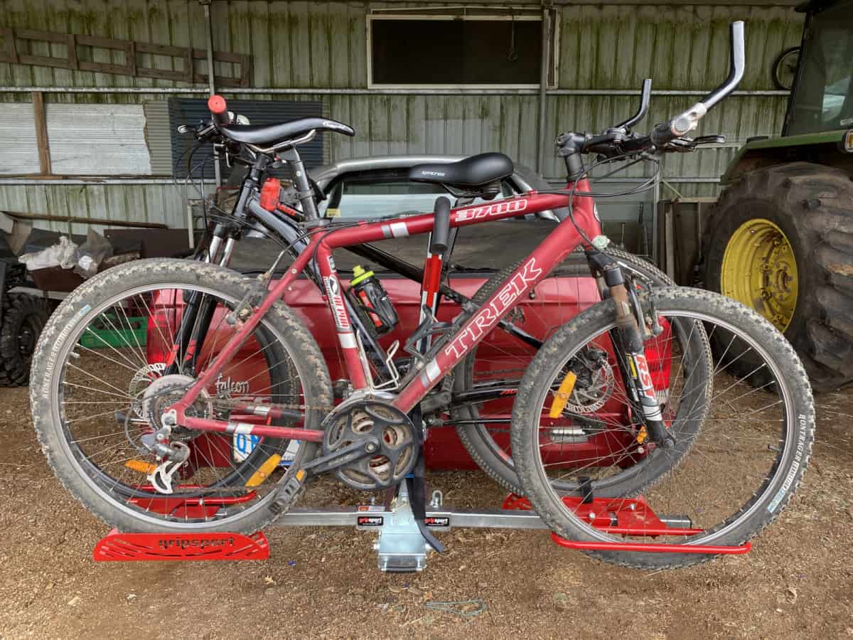 Two bikes are parked in a bike rack.