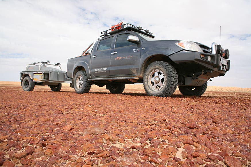 A truck and trailer are parked on the side of a road.