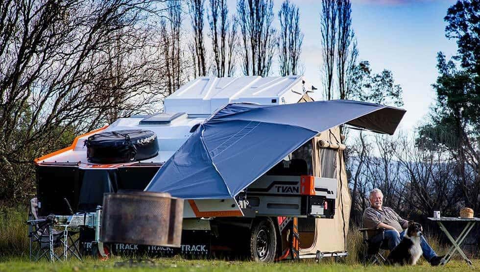 A blue umbrella is attached to an rv.