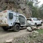 A truck and car are parked on the side of a road.