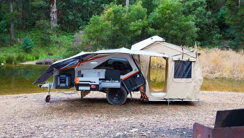 A truck with an awning and tent on the back.