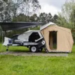 A tent that is attached to the back of a trailer.