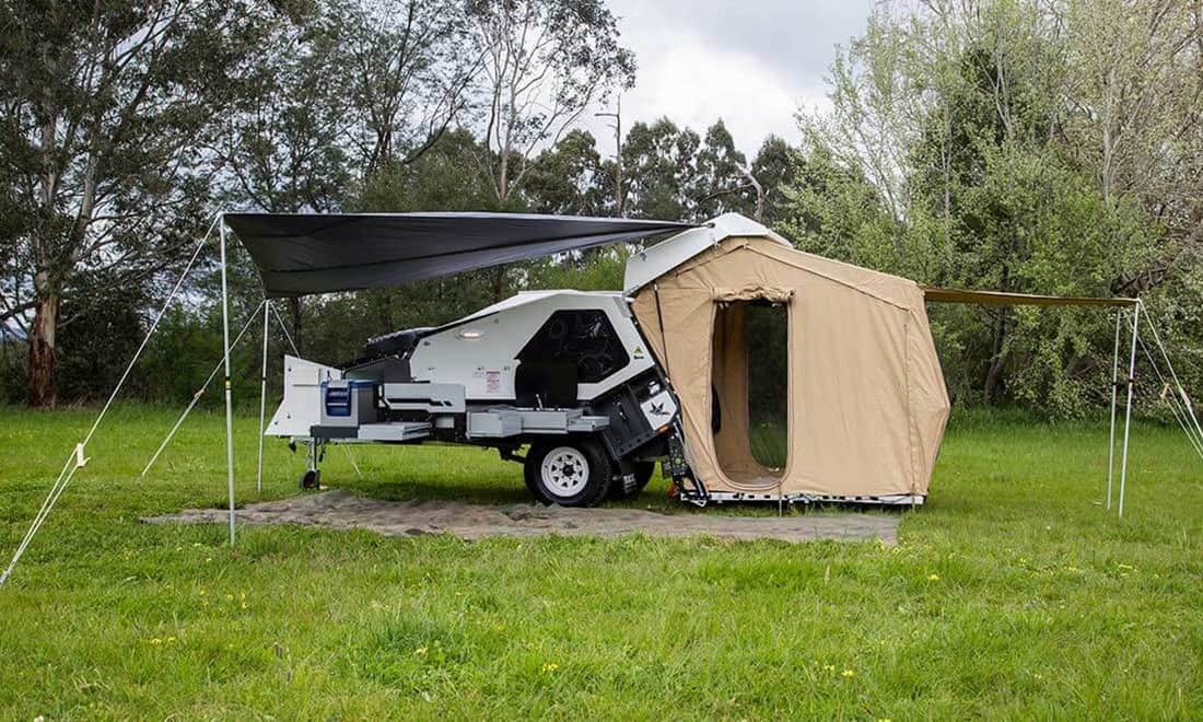 A tent that is attached to the back of a trailer.