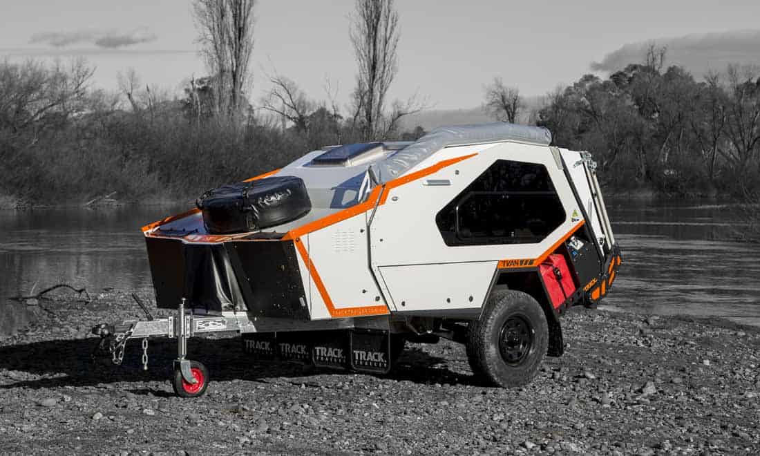 A small camper trailer with an orange stripe on it.