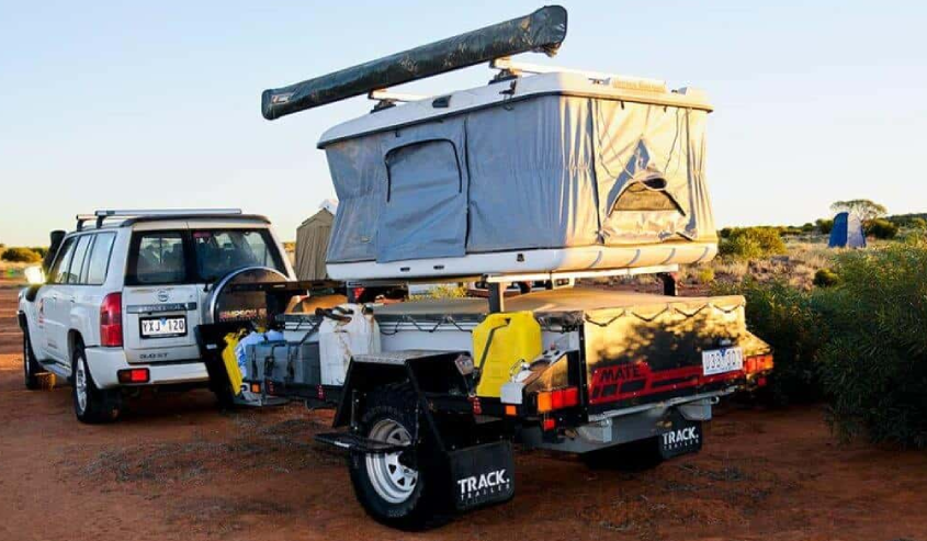 A trailer with an open tent on top of it.