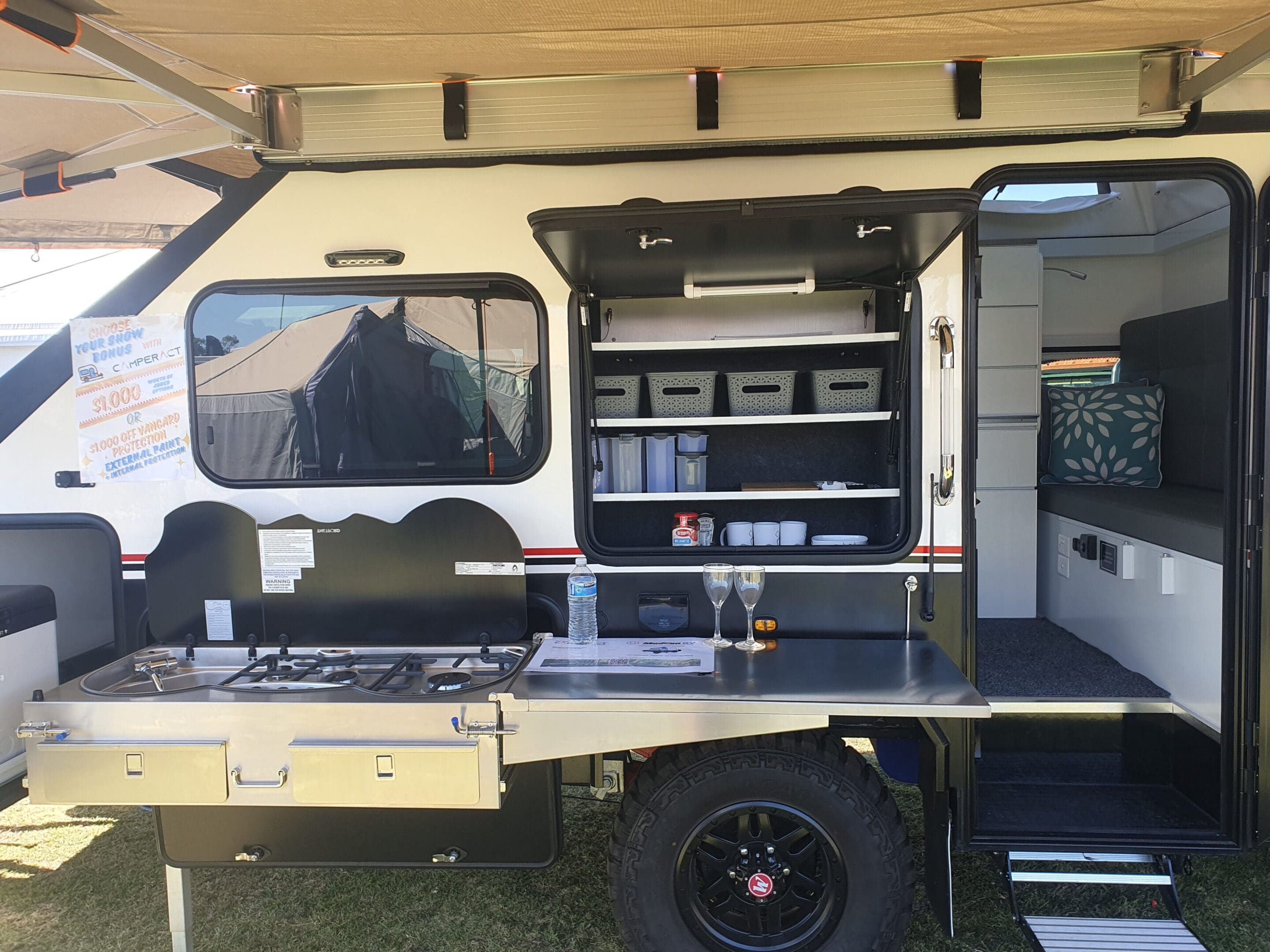 A truck with an open door and shelves in the back.