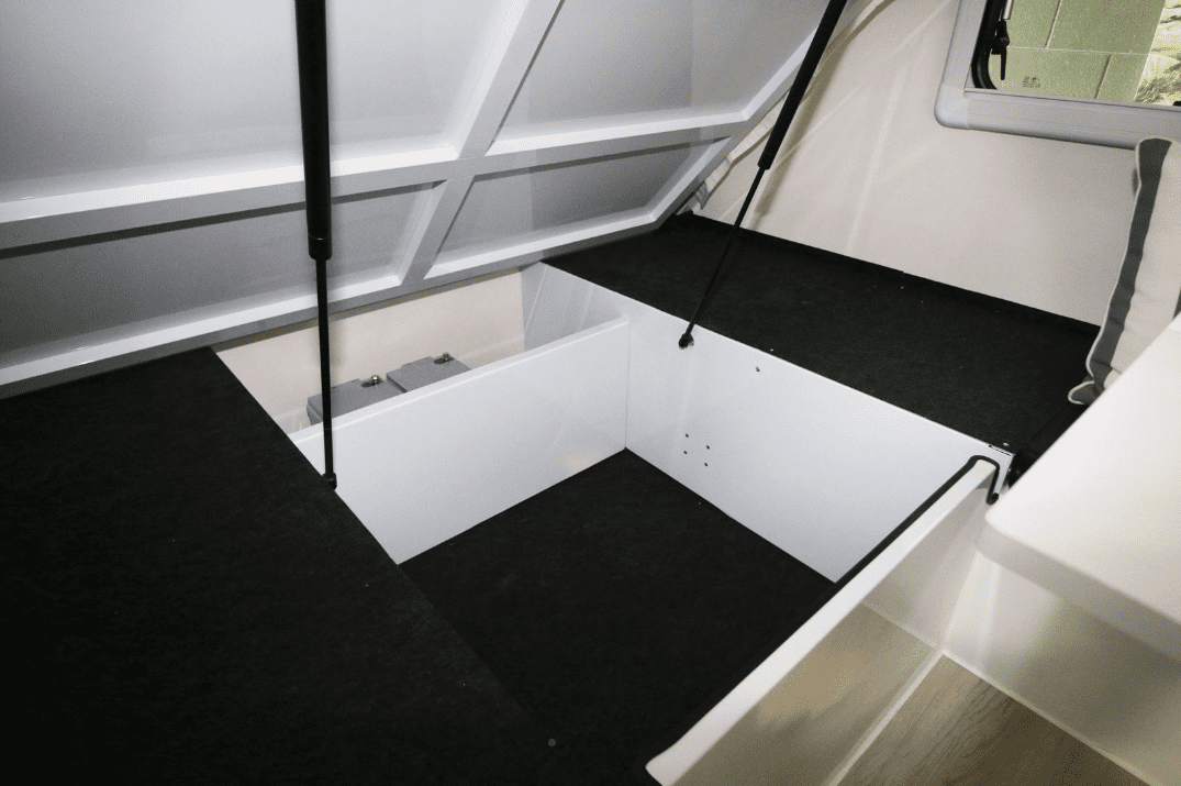 A white boat with black carpet and a black floor.